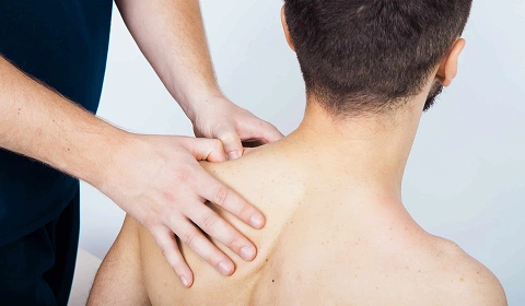 Therapist massaging patient’s shoulder.