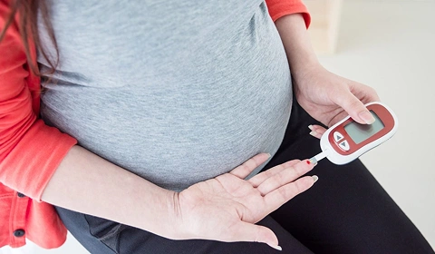 Pregnant woman checking blood sugar.